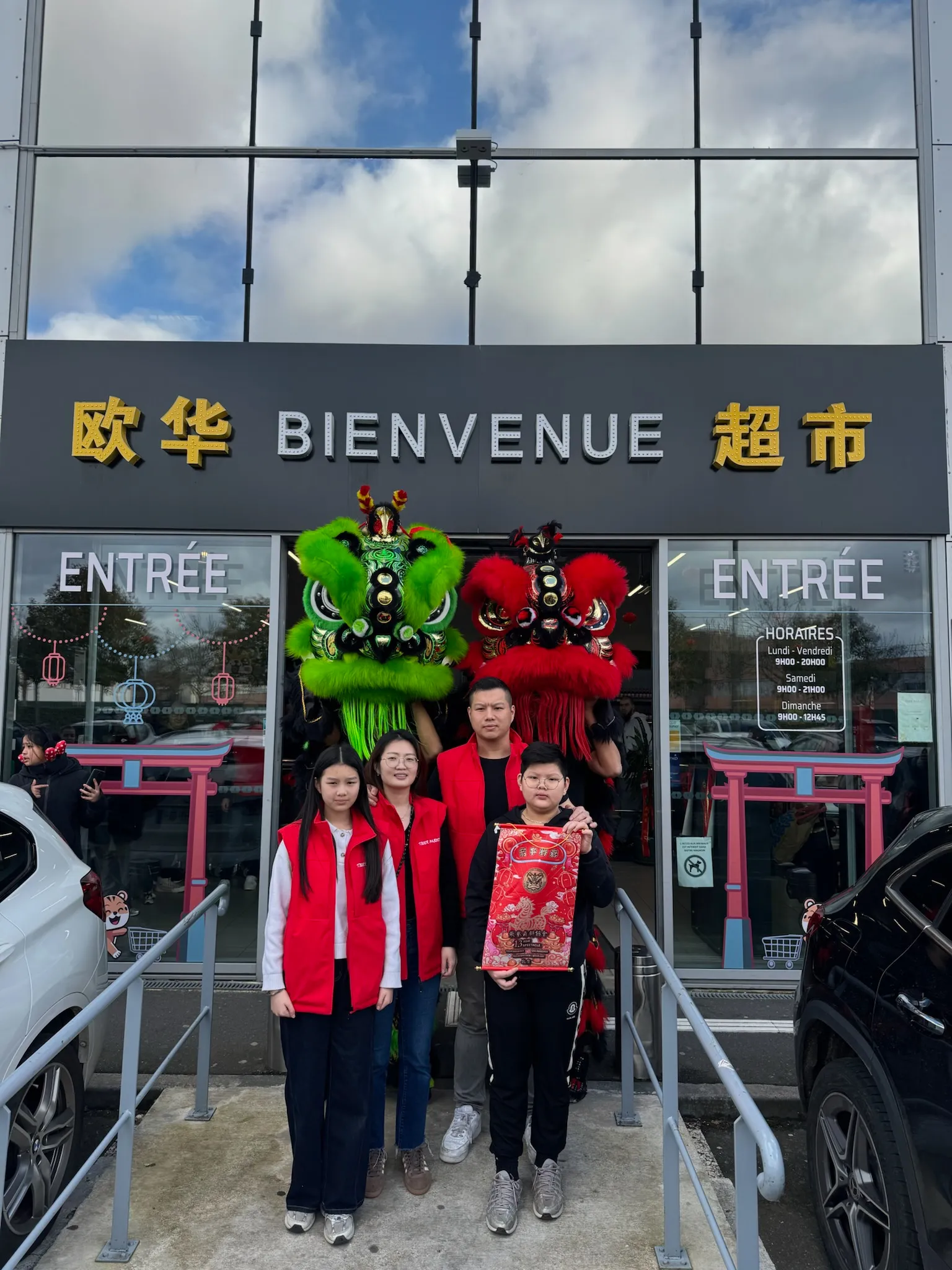 Lions et équipe devant l'entrée « Bienvenue » — inauguration 13AS