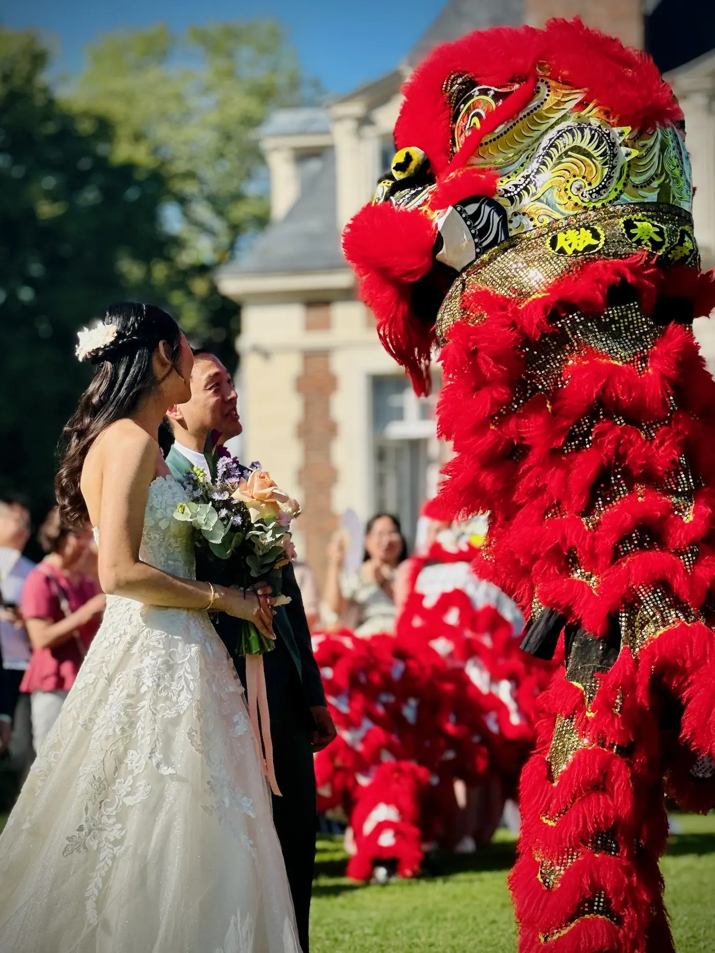 Mariés et lion rouge accompagnés des mascottes Dieu de la Fortune — cortège 13AS