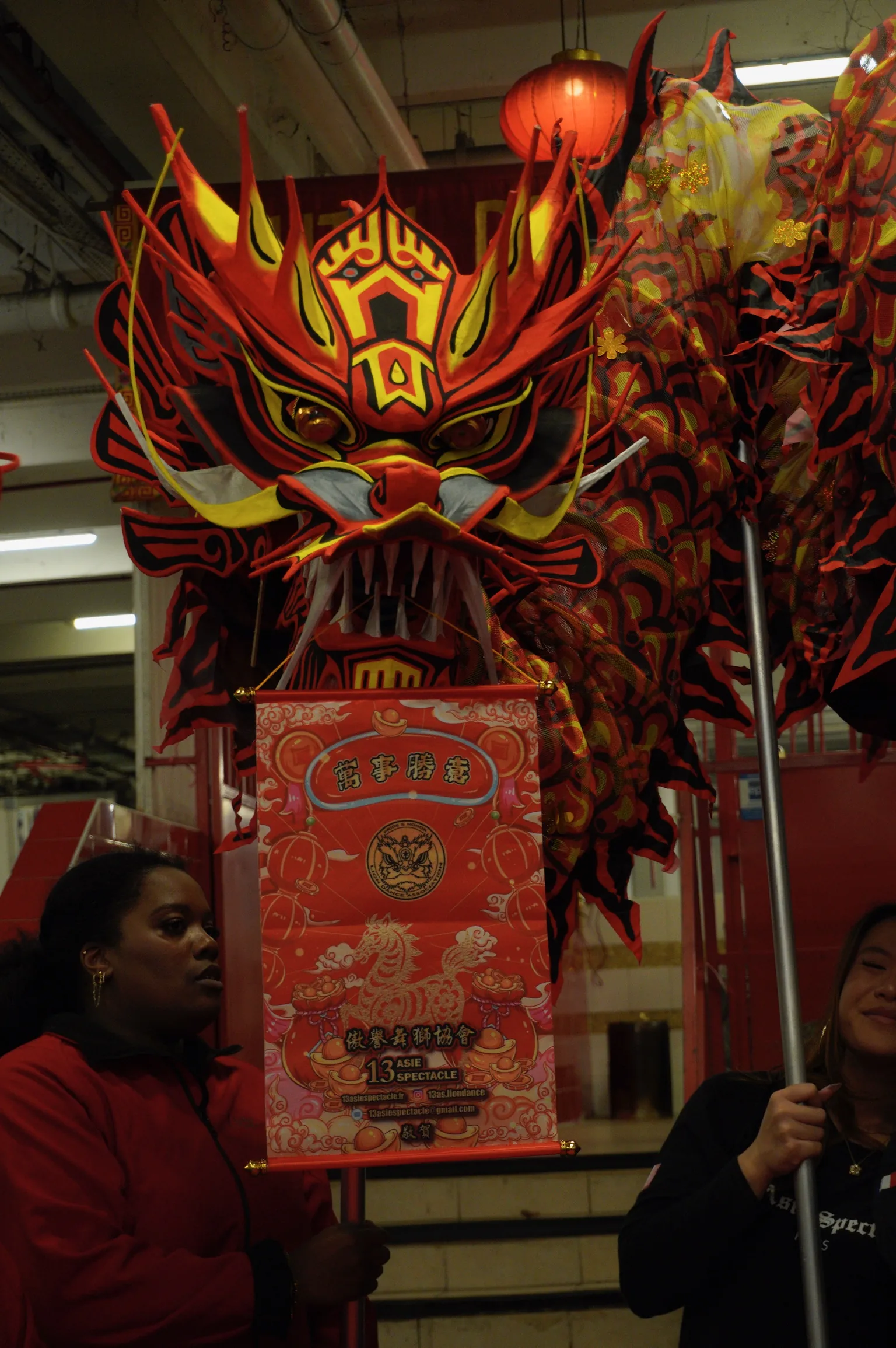 Tête de lion rouge et or en gros plan — détail costume 13AS